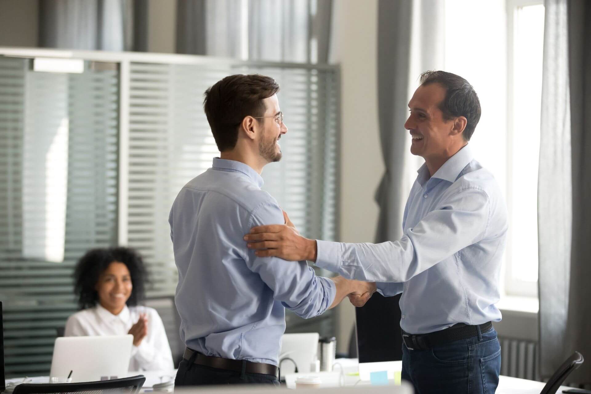 Businessman in suits holding hands.